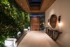 Modern home with Marble Floor, Exterior, Metal, Swing Door Type, House Building Type, Wood Siding Material, Green Roof Material, and Living Room. Vertical green living wall leads the visitors into the foyer. Photo 12 of Trousdale Place Residence