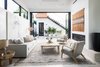 Modern home with Living Room, Sofa, Recessed Lighting, Gas Burning Fireplace, Porcelain Tile Floor, Coffee Tables, Lamps, End Tables, and Chair. The home's open design is perfect for indoor/outdoor living. Photo 9 of Milwood Residence