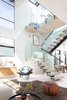 Modern home with Staircase, Glass Railing, Metal Railing, and Wood Tread. Natural light illuminates living area. Photo 3 of Milwood Residence