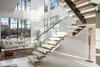 Modern home with Staircase, Wood Railing, Wood Tread, and Glass Railing. High ceilings brings natural light and views into the space. Photo 5 of Milwood Residence