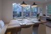 Modern home with Dining Room, Bench, Chair, Table, Light Hardwood Floor, and Pendant Lighting. Beautiful evening light in the dining area. Photo 2 of Live-in Kitchen