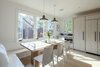 Modern home with Dining Room, Chair, Table, Storage, Bench, Light Hardwood Floor, Pendant Lighting, and Ceiling Lighting. Larger windows, white counter tops and bleached ash floors and cabinets all make the space bright and fresh. Photo 3 of Live-in Kitchen