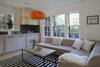 Modern home with Living Room, Sectional, Sofa, Coffee Tables, Pendant Lighting, Light Hardwood Floor, Rug Floor, and Gas Burning Fireplace. The ethanol-burning appliance by EcoSmart is a cozy focal point of the living area. Photo 6 of Live-in Kitchen