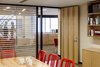 Modern home with Office, Study Room Type, Desk, Bookcase, Chair, Light Hardwood Floor, and Shelves. Semi-public spaces that connect to the exterior window wall are located along this public sequence to bring in natural light through wood screens. Photo 2 of Harvard Student Services