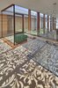 Modern home with Hallway and Limestone Floor. A screen covering an extensive side of the structure, filters light and creates a lovely pattern of swirling shadows on nearby surfaces. Photo of Hamptons Beach House