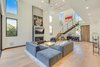 Modern home with Living Room, Chair, End Tables, Ottomans, Coffee Tables, Sofa, Ceiling Lighting, Sectional, Accent Lighting, Track Lighting, Standard Layout Fireplace, Floor Lighting, Light Hardwood Floor, and Gas Burning Fireplace. Main Living Area Photo 5 of The Rosewood Residence
