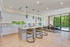 Modern home with Kitchen, Marble Counter, White Cabinet, Marble Backsplashe, Light Hardwood Floor, Ceiling Lighting, Accent Lighting, Pendant Lighting, Recessed Lighting, Refrigerator, Wall Oven, Dishwasher, Microwave, Ice Maker, Cooktops, Wine Cooler, and Drop In Sink. Kitchen/Dining Area Photo 6 of The Rosewood Residence