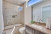 Modern home with Bath Room, Drop In Sink, Soaking Tub, Marble Counter, Enclosed Shower, Ceiling Lighting, Stone Tile Wall, One Piece Toilet, and Porcelain Tile Floor. Upstairs 2nd Bathroom Photo 17 of The Rosewood Residence