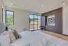 Modern home with Bedroom, Bookcase, Storage, Bed, Wardrobe, Chair, Ceiling Lighting, Recessed Lighting, Night Stands, Accent Lighting, Light Hardwood Floor, and Table Lighting. Master Suite Photo 19 of The Rosewood Residence