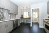 Modern home with Kitchen, Marble Counter, Dark Hardwood Floor, Recessed Lighting, Ceramic Tile Backsplashe, Wood Cabinet, Ceiling Lighting, Accent Lighting, Pendant Lighting, Dishwasher, Range, and Undermount Sink. More direct view into laundry nook. Photo 2 of Lincoln Kitchen