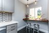 Modern home with Dining Room, Bar, Stools, Table, Chair, Accent Lighting, Ceiling Lighting, Pendant Lighting, and Dark Hardwood Floor. Close up of custom breakfast nook made from raw-edge reclaimed wood. Accessorized with found branch and fresh market flowers. Photo 3 of Lincoln Kitchen