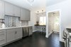 Modern home with Kitchen, Mosaic Tile Backsplashe, Wood Cabinet, Dark Hardwood Floor, Marble Counter, Recessed Lighting, Ceiling Lighting, Accent Lighting, Pendant Lighting, Undermount Sink, Dishwasher, and Range. View of kitchen from dining room doorway, featuring dwell tile backsplash. Photo of Lincoln Kitchen