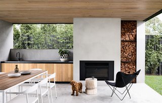 "A large loggia adjacent to the pool includes an outdoor kitchen and open fireplace. Timeless external finishes include cement render walls, metal fascias and timber soffits, and contrasting black powder-coated door frames and screens," says the architect and interior designer, InForm. 