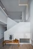 Modern home with Staircase, Wood Tread, and Wood Railing. With a tight budget, stud walls and drywall were used to add a second layer of "folded planes"
to the interior. Light falling on these walls sculpts the space. The origami concept enriches the interior everyday experience. Photo 5 of Arlington Solar