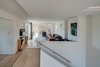Modern home with Living Room, Light Hardwood Floor, Gas Burning Fireplace, Sectional, and Recessed Lighting. The folded plane concept at the stair is mirrored at the kitchen and both bookend the loft space. Photo 8 of Arlington Solar