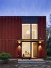 Modern home with Exterior, House Building Type, Flat RoofLine, Glass Siding Material, Metal Siding Material, and Metal Roof Material. Light from the east-facing entry animates the walls at the stair. Photo 4 of Arlington Solar