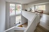 Modern home with Staircase, Wood Tread, and Wood Railing. A desk overlooks the stair where the Owner works remotely as project manager to a global telecom/IT company. Photo 7 of Arlington Solar