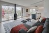 Modern home with Living Room, Sectional, Recessed Lighting, Pendant Lighting, Gas Burning Fireplace, and Light Hardwood Floor. The second floor exterior deck connects the inhabitants to the "ever-changing and ever-spectacular treetop view." Photo 9 of Arlington Solar
