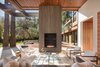 Modern home with Living Room, Sofa, Two-Sided Fireplace, Ceiling Lighting, Gas Burning Fireplace, Chair, and Light Hardwood Floor. Limestone wrapped monolithic wall with fireplaces on both sides Photo 7 of Ross Modern