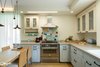 Modern home with Kitchen, Wood Counter, Tile Counter, Wood Cabinet, Medium Hardwood Floor, Ceiling Lighting, Colorful Cabinet, Ceramic Tile Backsplashe, and Range Hood. A closer look at the kitchen Photo 2 of An Ideal Home Renovation for the Golden Years