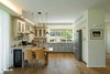 Modern home with Kitchen, Colorful Cabinet, Wood Cabinet, Wood Counter, Tile Counter, Medium Hardwood Floor, Ceramic Tile Backsplashe, Ceiling Lighting, Refrigerator, Wall Oven, Cooktops, Wine Cooler, Microwave, Dishwasher, and Vessel Sink. A look at the Kitchen Photo of An Ideal Home Renovation for the Golden Years