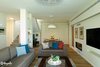 Modern home with Living Room, Coffee Tables, Table Lighting, Track Lighting, Ceiling Lighting, Sofa, Medium Hardwood Floor, and Gas Burning Fireplace. The living room Photo 3 of An Ideal Home Renovation for the Golden Years