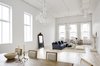 Modern home with Living Room, Sofa, Coffee Tables, Ottomans, Chair, Ceiling Lighting, Track Lighting, Pendant Lighting, Light Hardwood Floor, and Wood Burning Fireplace. Living Room Photo of Grand St. Residence