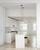 Modern home with Kitchen, Marble Counter, Light Hardwood Floor, White Cabinet, Stone Tile Backsplashe, Pendant Lighting, Recessed Lighting, and Drop In Sink. Kitchen Photo 2 of Grand St. Residence