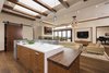 Modern home with Kitchen, Granite Counter, Engineered Quartz Counter, Wood Cabinet, Medium Hardwood Floor, Wood Counter, Ceiling Lighting, Pendant Lighting, Wall Lighting, Stone Slab Backsplashe, Recessed Lighting, Accent Lighting, and Undermount Sink. Open Concept Kitchen/Living Room Photo 4 of La Jolla Modern