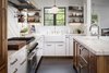 Modern home with Kitchen, Marble Counter, White Cabinet, Wood Cabinet, Medium Hardwood Floor, Subway Tile Backsplashe, Stone Slab Backsplashe, Pendant Lighting, Recessed Lighting, Range Hood, Range, Dishwasher, and Undermount Sink. Kitchen Photo 2 of Mission Hills Modern