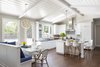 Modern home with Kitchen, Quartzite Counter, Stone Tile Backsplashe, Medium Hardwood Floor, White Cabinet, Engineered Quartz Counter, Range Hood, Refrigerator, Cooktops, Pendant Lighting, and Undermount Sink. Open and Light Kitchen Photo of Danville Transitional Remodel
