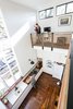 Modern home with Kitchen, Wood Counter, Dark Hardwood Floor, White Cabinet, Ceramic Tile Backsplashe, Wall Oven, Refrigerator, and Drop In Sink. The double height interior space overlooks the kitchen. A large custom operable assembly of windows frames views to the Oak lined street. Photo 3 of Dorgenois