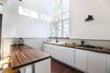 Modern home with Kitchen, Wood Counter, White Cabinet, Dark Hardwood Floor, Ceramic Tile Backsplashe, Wall Lighting, Drop In Sink, and Dishwasher. The light-filled kitchen space. Cle tiles are used as backsplash, Ikea cabinets and Walnut butcher-block countertops make the working surfaces of the space. Photo 8 of Dorgenois