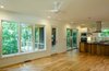 Modern home with Kitchen, Engineered Quartz Counter, White Cabinet, Granite Counter, Wood Cabinet, Light Hardwood Floor, Mirror Backsplashe, Ceiling Lighting, Accent Lighting, Range, Range Hood, Microwave, Refrigerator, Wall Oven, Dishwasher, and Undermount Sink. Kitchen and Screen Porch Photo 7 of Tree House