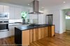 Modern home with Kitchen, Granite Counter, Engineered Quartz Counter, White Cabinet, Wood Cabinet, Ceiling Lighting, Recessed Lighting, Light Hardwood Floor, Mirror Backsplashe, Refrigerator, Wall Oven, Range, Microwave, Range Hood, Undermount Sink, and Dishwasher. Kitchen Photo 8 of Tree House