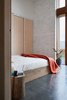 Modern home with Bedroom, Night Stands, Wardrobe, Ceiling Lighting, Bed, Wall Lighting, and Concrete Floor. Looking into the second bedroom featuring the home's recycled brick walls with a light natural, no VOC coat of paint. Photo 7 of The 10 Star Home