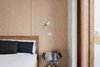 Modern home with Bedroom, Bed, Chair, Ceiling Lighting, Night Stands, Wall Lighting, Accent Lighting, and Concrete Floor. Main bedroom featuring recycled brick walls and sustainable, non-toxic plywood panelling. Sustainable timber bed by Totem Road. Photo 2 of The 10 Star Home