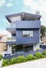 Modern home with Outdoor, Front Yard, Shrubs, and Horizontal Fences, Wall. One of the main challenges during construction was the aggressive cantilevered roof, which became integral to the climatic, covered deck space. Large steel beams, clad in wood, made this special feature possible. The balcony walls alternate between solid surface, to create privacy, and transparent glass railings, to capture the view of the ocean. Photo of Manhattan Ave Residence