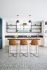 Modern home with Kitchen, Marble Counter, Metal Cabinet, Stone Slab Backsplashe, Cement Tile Floor, Accent Lighting, Beverage Center, and Undermount Sink. The beach room bar utilizes high windows, due to the sunken retaining walls required at the upper end of the site. Dark stone slabs compliment the coated steel shelving. Raw leather stools provide the accent of color, against the personality of the cement tile floor. Photo 9 of Manhattan Ave Residence