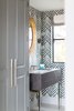 Modern home with Bath Room, Marble Counter, Undermount Sink, and Porcelain Tile Floor. The powder rooms were allowed extra personality. A full slab vanity is set on chrome legs, against a bamboo print wallpaper and decorative mirror. Photo 10 of Manhattan Ave Residence