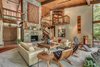 Modern home with Living Room, Chair, Sofa, Recliner, Coffee Tables, End Tables, Bookcase, Ceiling Lighting, Track Lighting, Accent Lighting, Medium Hardwood Floor, Wood Burning Fireplace, Ceramic Tile Floor, and Standard Layout Fireplace. Living Room Photo 6 of Beautifully Designed Contemporary