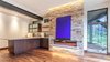 Modern home with Living Room, Ceiling Lighting, Accent Lighting, Table Lighting, Recessed Lighting, Floor Lighting, Medium Hardwood Floor, and Gas Burning Fireplace. Lower Family Room Photo 13 of Beaver Dam Luxury
