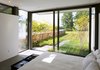 Modern home with Bed, Ceiling Lighting, Windows, Limestone Floor, Metal, Picture Window Type, and Sliding Window Type. A guest suite with bath and changing areas has a large sliding door out to a private garden. Photo 6 of A Summer House
