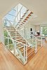 Modern home with Metal Tread, Wood Tread, Glass Railing, Metal Railing, Coffee Tables, End Tables, Chair, Ottomans, Ceiling Lighting, Gas Burning Fireplace, Light Hardwood Floor, Ribbon Fireplace, Windows, Picture Window Type, and Metal. staircase Photo 7 of Westlake1