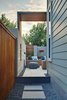 Modern home with Chair, Ottomans, Sofa, Floor Lighting, Outdoor, Travertine Floor, Back Yard, Shrubs, Gardens, Walkways, Raised Planters, Hardscapes, Large Patio, Porch, Deck, Stone Patio, Porch, Deck, Horizontal Fences, Wall, Small Pools, Tubs, Shower, Concrete Pools, Tubs, Shower, Landscape Lighting, Vertical Fences, Wall, and Wood Fences, Wall. side yard entry Photo of Mueller 1
