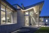 Modern home with Exterior, House, Mid-Century Building Type, Metal Roof Material, Stucco Siding Material, Stone Siding Material, Glass Siding Material, and Butterfly RoofLine. Entry detail and guest wing featuring one of the rainwater harvesting cistern collectors Photo 2 of The U V House