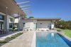 Modern home with Outdoor, Back Yard, Shrubs, Large Pools, Tubs, Shower, Swimming Pools, Tubs, Shower, Lap Pools, Tubs, Shower, Hardscapes, Raised Planters, Infinity Pools, Tubs, Shower, Concrete Pools, Tubs, Shower, Large Patio, Porch, Deck, Tile Patio, Porch, Deck, and Stone Patio, Porch, Deck. Rear outdoor living looking west toward the guest wing, featuring the negative edge pool, and "eyelash" shade fade detail Photo 3 of The U V House