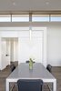 Modern home with Dining Room, Chair, Table, Ceiling Lighting, Pendant Lighting, and Ceramic Tile Floor. Dining room detail featuring the minor axis mill work detail, and portal to the mud/laundry/desk/garage area Photo 10 of The U V House