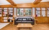 Modern home with Living Room, Bookcase, Sofa, End Tables, Coffee Tables, Bench, Track Lighting, Table Lighting, Wood Burning Fireplace, Accent Lighting, and Cork Floor. Living Room Photo 7 of Classic Mid Century Modern home for sale