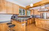 Modern home with Kitchen, Cork Floor, Wood Cabinet, Wood Counter, Track Lighting, Metal Backsplashe, Pendant Lighting, Refrigerator, Range, Accent Lighting, Dishwasher, Drop In Sink, Wall Oven, Undermount Sink, and Range Hood. Custom Birch Kitchen Photo 11 of Classic Mid Century Modern home for sale